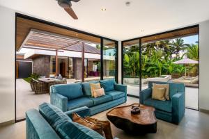 uma sala de estar com sofás azuis e uma mesa em Villa mon Rêve em Ubud
