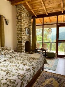 a bedroom with a bed and a stone fireplace at Happy Dervish, Nathuakhan, Mukteshwar in Mukteswar