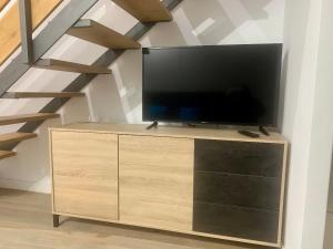 una TV a schermo piatto su un comò accanto a una scala di PUERTA DE CACERES Apartamento 4 a Cáceres