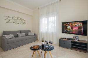 a living room with a couch and a tv at Center Manolia Dream 3 Bedroom Apartment 100m away from the beach in Chania Town