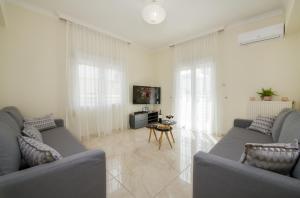 a living room with two couches and a table at Center Manolia Dream 3 Bedroom Apartment 100m away from the beach in Chania Town