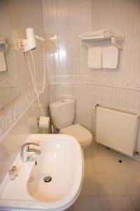 een witte badkamer met een toilet en een wastafel bij Pensiunea Eden Caransebes in Caransebeş