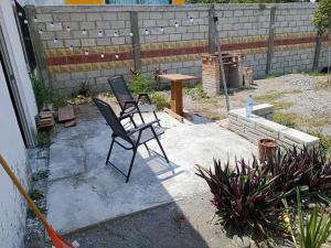 2 chaises et une table dans la cour dans l'établissement Hostal a 10 min del centro de Veracruz, à Veracruz