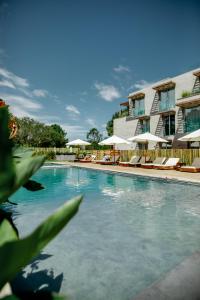 uma piscina com cadeiras e guarda-sóis ao lado de um edifício em Casagrande Hotel & Beach Club em José Ignacio