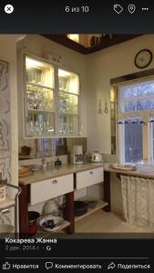 uma cozinha com armários brancos, um lavatório e janelas em rantatalo em Savitaipale