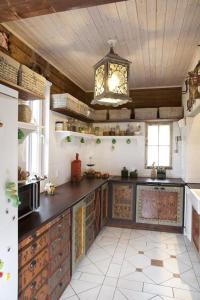 a large kitchen with wooden cabinets and a chandelier at rantatalo in Savitaipale