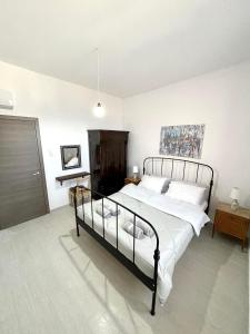 een slaapkamer met een groot bed met witte lakens bij Ritsos Family Apartment in Monemvasia