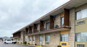 un bâtiment avec balcon et une voiture garée dans un parking dans l'établissement Travelodge by Wyndham Bloomington, à Bloomington