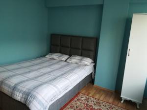 a bedroom with a bed with a blue wall at Setpark Apart Otel in Bursa