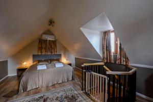 a attic bedroom with a bed and a staircase at GouldVilla Vendégház in Villány +63 photos