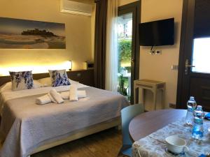 a bedroom with a bed with a table and a television at International Rooms & Apartments in Sirmione