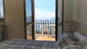 a bedroom with a bed and a view of a balcony at Panorama Verde Lago - Mountain Lake Iseo Hospitality in Bossico