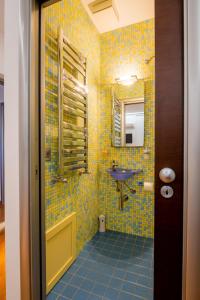 uma casa de banho com azulejos amarelos e um lavatório em Antadia em Palermo