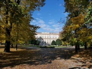 a large white building with trees in the foreground at Locanda San Paolo in Monza