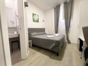 a small bedroom with a bed and a desk at Monte Zebio Boutique Suites in Rome