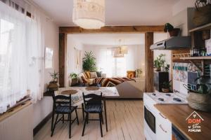 a kitchen and living room with a table and chairs at Dom w sercu Pomlewa in Pomlewo