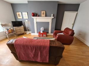a living room with a couch and a chair at Brewsters by Spires Accommodation a comfortable place to stay in the heart of Burton-upon-Trent in Burton upon Trent