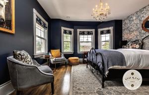 a bedroom with blue walls and a bed and a chandelier at Slaymaker & Nichols Gastro House & Inn in Charlottetown +37 photos