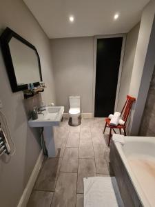 a bathroom with a sink and a tub and a toilet at Brewsters by Spires Accommodation a comfortable place to stay in the heart of Burton-upon-Trent in Burton upon Trent