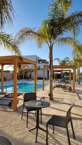 a patio with a table and chairs next to a pool at CIRERA SICILY in Marzamemi