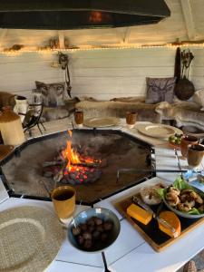 a table with a grill with food and a fire at Det blågrønne Hus in Hals