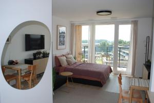 Un dormitorio con una cama y una habitación con una mesa. en Apartament CITY BREAK 124, en Varsovia