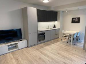 una cucina con tavolo, TV, tavolo e sedie di Laugavegur Apartment a Reykjavik