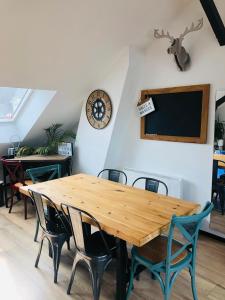 a dining room with a wooden table and chairs at "LA FABRIQUE" en HYPERCENTRE PARKING GRATUIT in Amiens