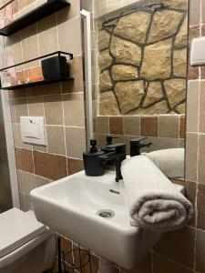 La salle de bains est pourvue d'un lavabo et d'un mur en pierre. dans l'établissement Apartman Ksenija, à Zadar