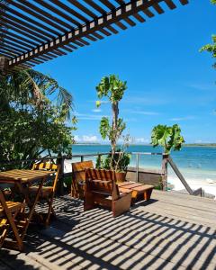 a wooden deck with tables and chairs on the beach at Pousada e Restaurante do Paulo in Jijoca de Jericoacoara
