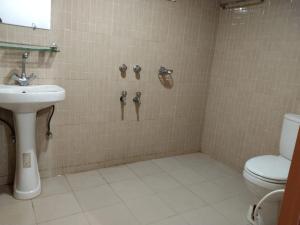 a bathroom with a toilet and a sink at Jungle cottage in Sreemangal