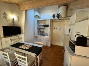 eine Küche mit einem Tisch und Stühlen im Zimmer in der Unterkunft La mansarda in centro in Modena