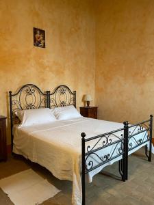 Agriturismo I Bosconi في تشيسينا: غرفة نوم بسرير اسود مع مخدات بيضاء