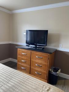 Schlafzimmer mit einem TV auf der Kommode in der Unterkunft Farwest Motel in Everett
