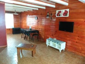 sala de estar con TV y mesa en Departamentos Muñoz en Río Grande