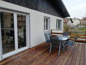 a patio with a table and chairs on a deck at Le Petit Cabanon in Sapois