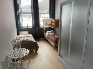 Cette chambre comprend un lit, une table et une chaise. dans l'établissement Eidsdal Rest House, à Eidsdal