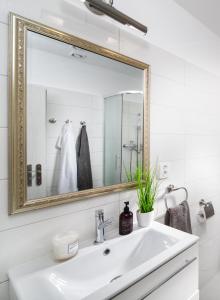 een witte badkamer met een wastafel en een spiegel bij Apartmán U Pramene in Františkovy Lázně