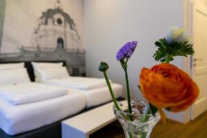 a room with a couch and a vase with flowers in it at Room 55 in Vienna