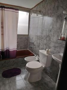 y baño con aseo y lavamanos. en Departamentos Muñoz en Río Grande