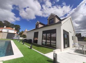a house with a swimming pool and a yard at Marisol Sunset in Charneca
