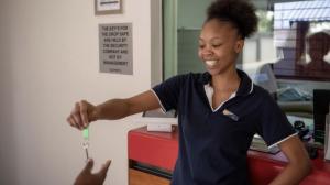 a woman is smiling while holding a toothbrush at Ecomotel O.R.Tambo in Kempton Park