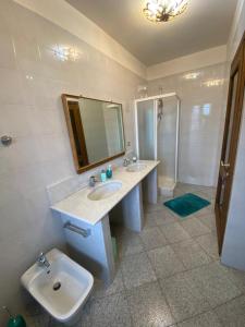 een badkamer met 2 wastafels, een toilet en een spiegel bij La Casetta di Badolo in Sasso Marconi