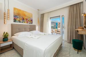 a bedroom with a large white bed and a window at Ninemia Studios in Limenas