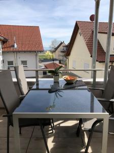 een tafel en stoelen op een balkon bij Zeitlos Bodensee in Friedrichshafen