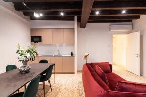 un salon avec un canapé rouge et une table dans l'établissement Palazzo Miracoli Apartments, à Venise