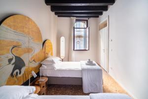 a bedroom with two beds and a large painting on the wall at Palazzo Miracoli Apartments in Venice