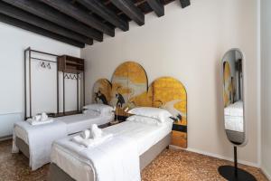 3 camas en una habitación con una pintura en la pared en Palazzo Miracoli Apartments, en Venecia