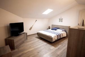 a bedroom with a bed and a flat screen tv at Entre Terre et Mer in Marsillargues