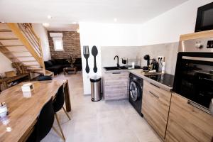 a kitchen with a dining table and a living room at Entre Terre et Mer in Marsillargues